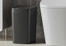 a black trash can in a bathroom