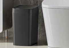 a black trash can in a bathroom
