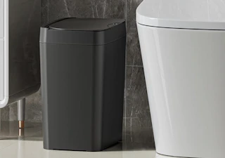 a black trash can in a bathroom