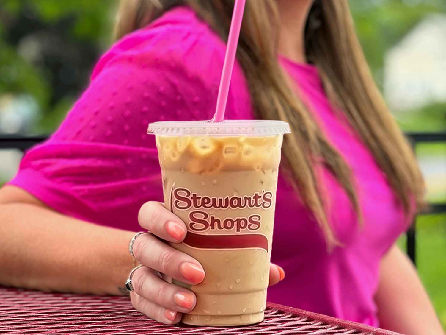 a person holding a stewarts cup of coffee