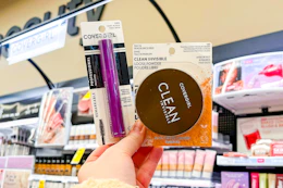 hand holding covergirl powder and mascara