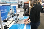 A woman using the touchpad of a display laptop in the computer section at Best Buy.