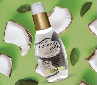 Ogx serum on a green background with coconut