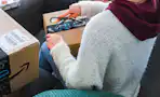 a woman opening an amazon package