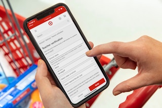 A person holding their iPhone, filling out the Teacher Verification form on the Target circle app.