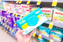 person holding a pack of pampers baby wipes in front of other baby wipes