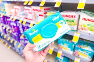 person holding a pack of pampers baby wipes in front of other baby wipes