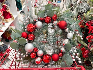 A red North Pole wreath sitting in a store cart.