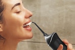 a woman using a water flosser