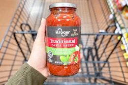 hand holding a jar of kroger pasta sauce