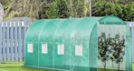 a greenhouse with fruit trees in a yard