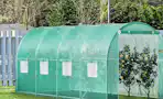 a greenhouse with fruit trees in a yard