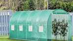 a greenhouse with fruit trees in a yard