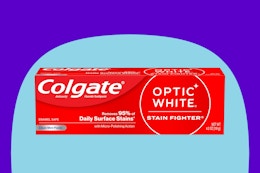 Colgate Optic White Stain Fighter Teeth Whitening Toothpaste on a blue background.