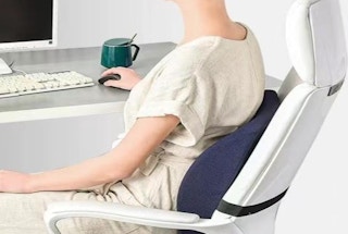 a woman sitting in an office chair at a desk with a computer