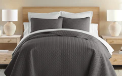 a brown quilt set on a bed