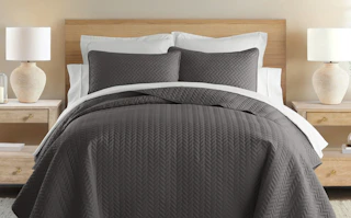 a brown quilt set on a bed