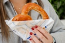 a person holding up an auntie annes pretzel