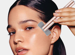 a person using a red light therapy wand on their face