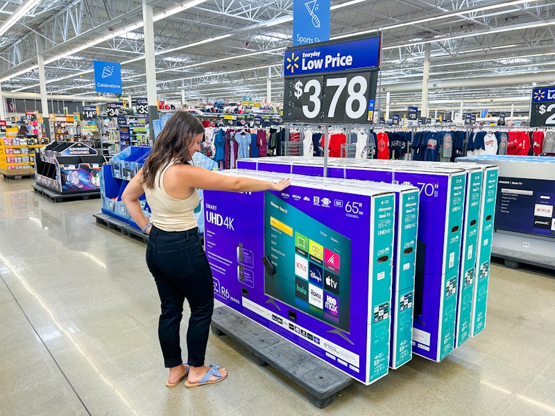 a person looking at TVs in walmart