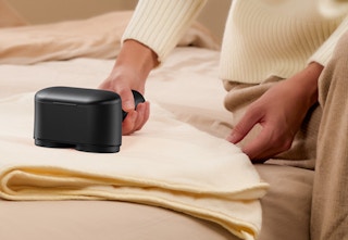 person using fabric shaver on towel