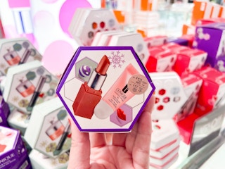someone holding a clinique small makeup gift set