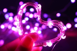 a woman holding fairy lights