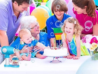 A family having a party outside with balloons, cake, and bubbles