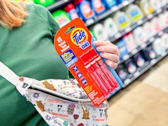 3-pack of Tide To Go Pens held over purse in Walmart store
