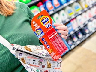 3-pack of Tide To Go Pens held over purse in Walmart store