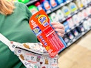 3-pack of Tide To Go Pens held over purse in Walmart store