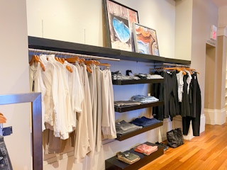 clothes on shelfs and on hangers hung on racks in the mens section in banana republic