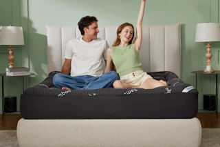 couple sitting on top of mattress topper