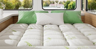 a mattress topper on a bed above a window