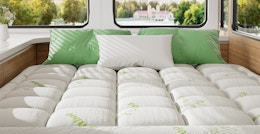 a mattress topper on a bed above a window