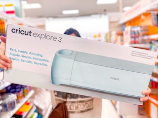 hand holding a cricut explore 3 in a target aisle