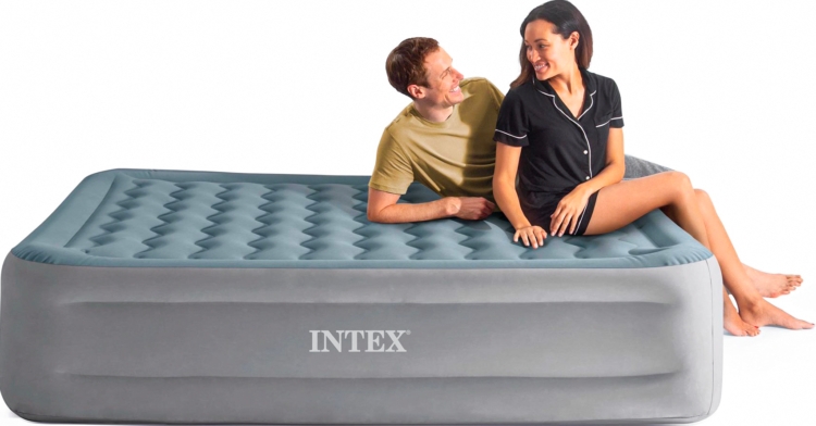 Two people sitting on an Intex comfort queen air mattress