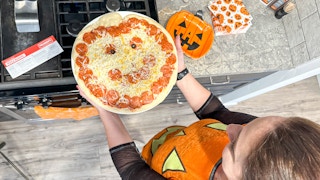 a person holding a papa murphys halloween pizza