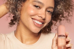 a woman holding a bottle of kitsch perfume