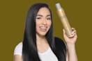a person holding a gold can of hair sray