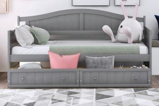 Lifestyle image of the Qualler Twin Daybed in gray (bedroom setting)
