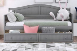 Lifestyle image of the Qualler Twin Daybed in gray (bedroom setting)