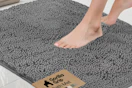 person stepping onto a gray bath rug