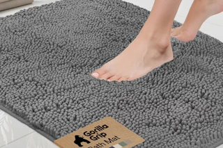 person stepping onto a gray bath rug