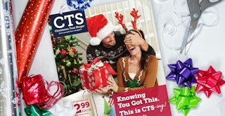 A Christmas Tree Shops weekly ad flyer on a table with some gift wrapping supplies