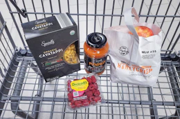 pasta, raspberries, pasta sauce, and apples in a cart