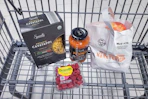 pasta, raspberries, pasta sauce, and apples in a cart
