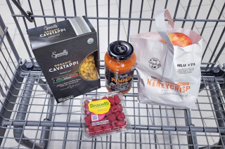 pasta, raspberries, pasta sauce, and apples in a cart