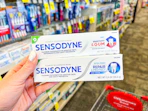 hand holding sensodyne toothpastes in cvs