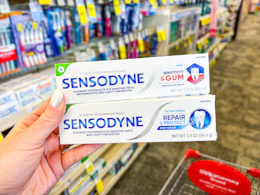 hand holding sensodyne toothpastes in cvs